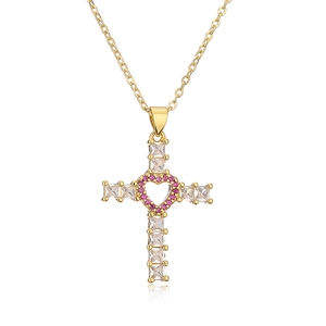 Collier croix dorée avec zircons carrés et pendentif coeur en strass roses sur fond blanc