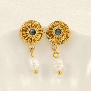 Detail of vintage gold star earrings with blue gemstone and baroque pearl drop