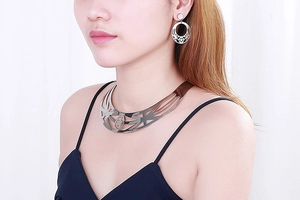 Detail of silver hollow star necklace and earrings set worn on a female model
