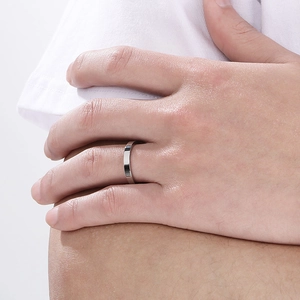 Close-up of a minimalist 3mm silver stainless steel ring on a finger with a clean aesthetic
