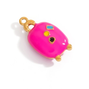 Detailed macro view of gold-plated enamel unicorn charm with vibrant pink and blue colors