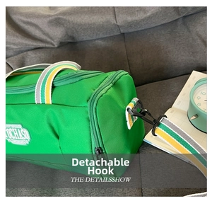 Detail of green cylinder sports bag showing detachable black plastic hooks and logo