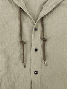 Detail of khaki linen hooded shirt showing fabric texture, drawstring, and round buttons