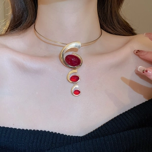 Detail of a gold choker necklace featuring three elegant red oval resin stones for women