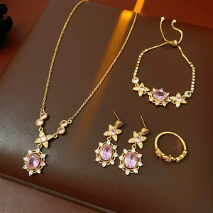 Detailed flat lay of vintage gold jewelry set featuring pink oval gemstones and crystals