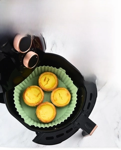 Silicone air fryer liners with side handles showing fries and tarts in use