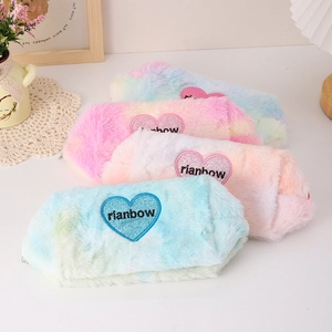 Detail of four colorful tie-dye plush pencil cases with heart shaped rainbow embroidery