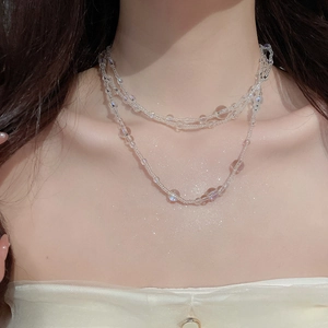Close-up of double-layered iridescent glass bead necklace on neck with rainbow luster