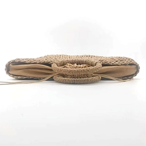 Top view of handmade crescent straw tote bag with brown drawstring lining and woven handle