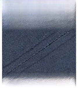 Close-up of dark blue polka dot denim fabric with precise diagonal stitching details