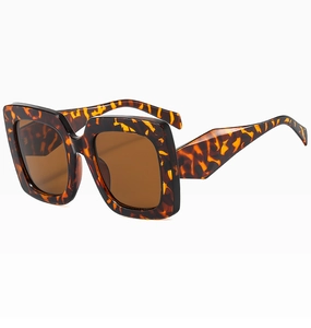 Detail view of oversized tortoise shell square sunglasses with wide temples