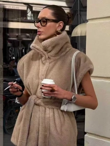 Détail du gilet élégant en fausse fourrure beige avec col montant et ceinture à la taille