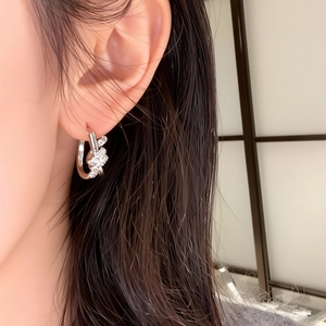 Silver knot hoop earrings with micro zircon inlays shown on ear for fashion wear