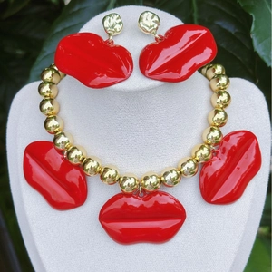 Vista detallada del conjunto de collar y pendientes de labios rojos en un busto.