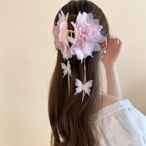 Detail of pink mesh flower hair claw clip with rhinestones and butterfly tassel chains
