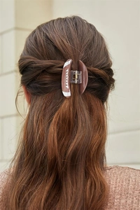 Close-up of a brown football hair claw clip styled on long hair with sports aesthetic