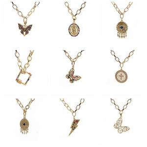 Collage de neuf colliers dorés avec pendentifs papillon, religieux, œil et éclair