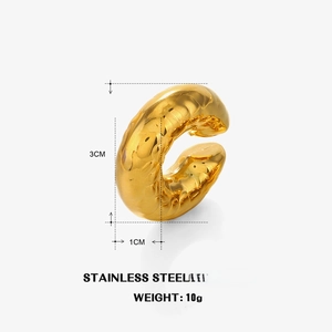 Détail macro de la boucle d'oreille en C plaqué or 18K avec une surface texturée