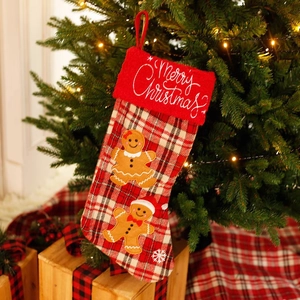 Plaid Christmas stocking with gingerbread man embroidery hanging on a festive Xmas tree
