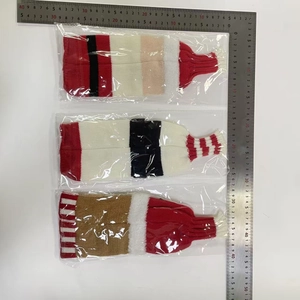 Detailed view of Christmas knitted wool wine bottle covers in festive red and white patterns