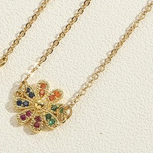 Macro shot of gold sunflower pendant with colorful rhinestones on textured leather