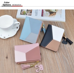 Detailed view of color-block PU leather wallets with rabbit head pendants and tassels