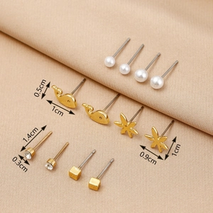 Detail view of pearl and gold stud earring set with precise dimensions on beige background