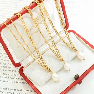 Triple set of layered gold-tone necklaces with baroque freshwater pearls in a red gift box