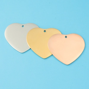 Close-up of polished heart-shaped pendants in silver, gold, and rose gold finishes