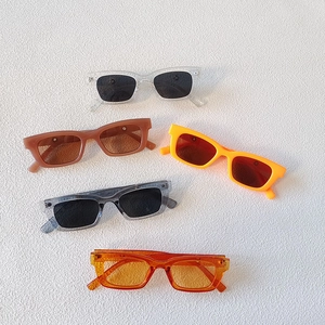 Rectangle jelly color sunglasses in five vibrant shades on white textured surface