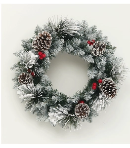 Close-up of PE mixed Christmas wreath with pine cones, red berries, and white snow flocking