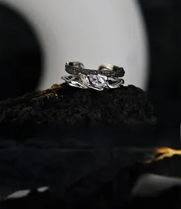 Macro shot of dual-layer S925 silver ring with marquise cut zircons on dark stone