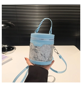 Detail of light blue PU leather and lace bucket bag with shoulder strap and metal hardware