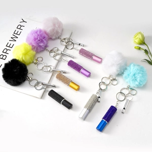 Detailed view of seven colorful faux fur pompom keychains with rhinestone lipstick charms