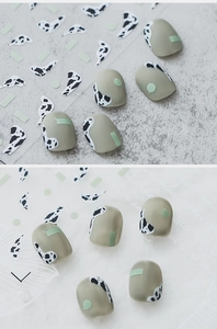 Detailed view of matte cow print and Morandi green geometric nail stickers on background