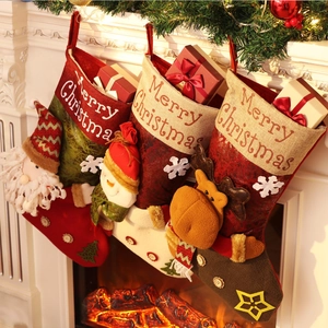 Close-up of knitted Christmas stockings with 3D Santa, snowman and reindeer on a mantel
