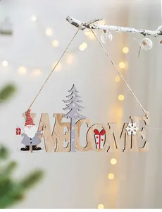 Detail of wooden Welcome Christmas sign with Santa and cedar hung on white branches