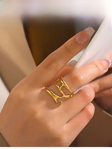 Detailed view of an irregular gold-plated cutout ring with minimalist fluid lines