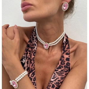 Detail showing elegant multi-layer pearl necklace and pink oval gemstone jewelry set on model