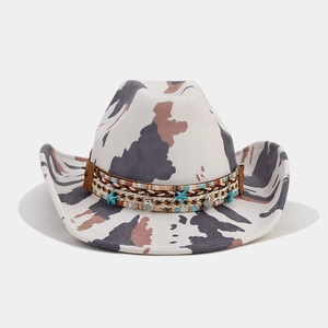 Detail of western cow print hat featuring blue starfish and silver shell charms