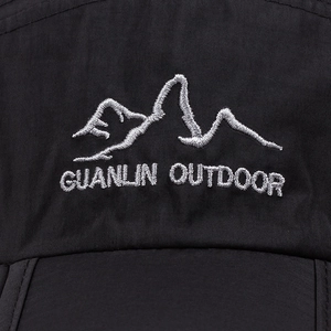 Detailed macro shot of mountain embroidery on a black quick-dry nylon outdoor cap