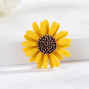 Modern sunflower brooch with yellow petals and bronze center on a white background