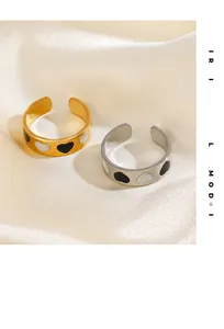 Detail of adjustable heart rings with black and white enamel on a satin background