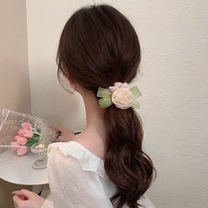 Elegant floral mesh scrunchie with pink rose design worn on a low ponytail hair style
