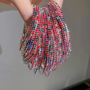 Macro detail of hand holding vibrant colorful crystal rhinestone stretch bracelets set