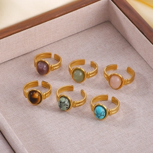 Set of six vintage gold-plated open rings with colorful natural stones on display