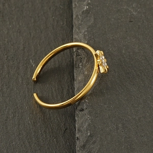 Détail macro d'une bague ouverte en or 18k avec étoile sertie de zircon sur pierre sombre