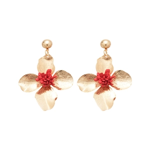 Elegant gold metal flower drop earrings with red textured center on white background