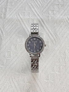 Top-down view of silver quartz watch with rhinestone bezel and dark gray dial detail