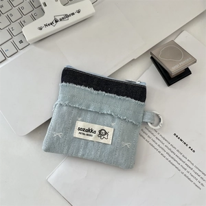 Makroaufnahme der Patchwork-Jeans-Geldbörse mit Stickerei auf weißem Laptop-Hintergrund